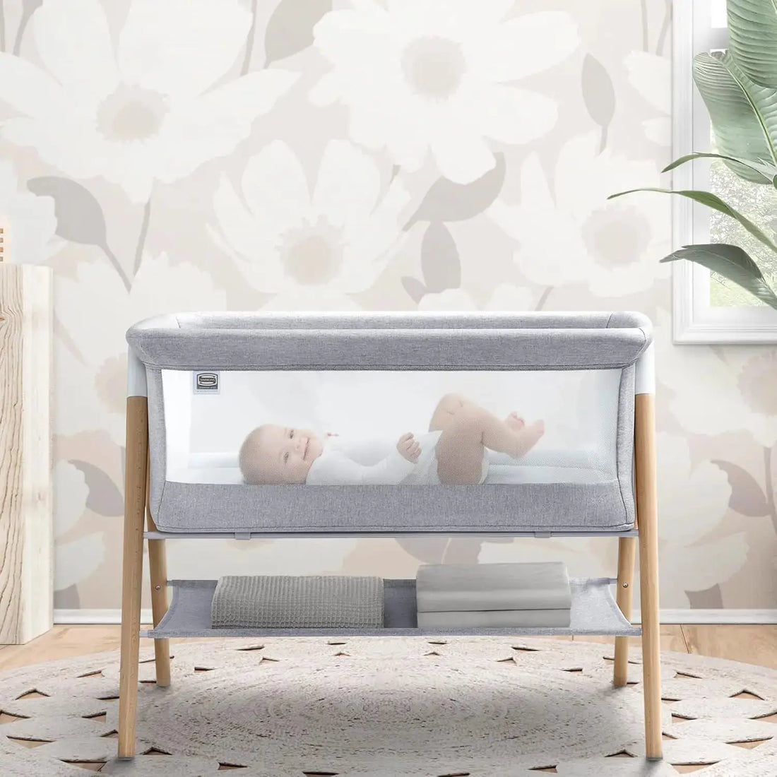 Koi by The Bed Bassinet with breathable mesh sides and natural beechwood legs in dove grey. Features a lower storage shelf, ideal for newborns and parents.