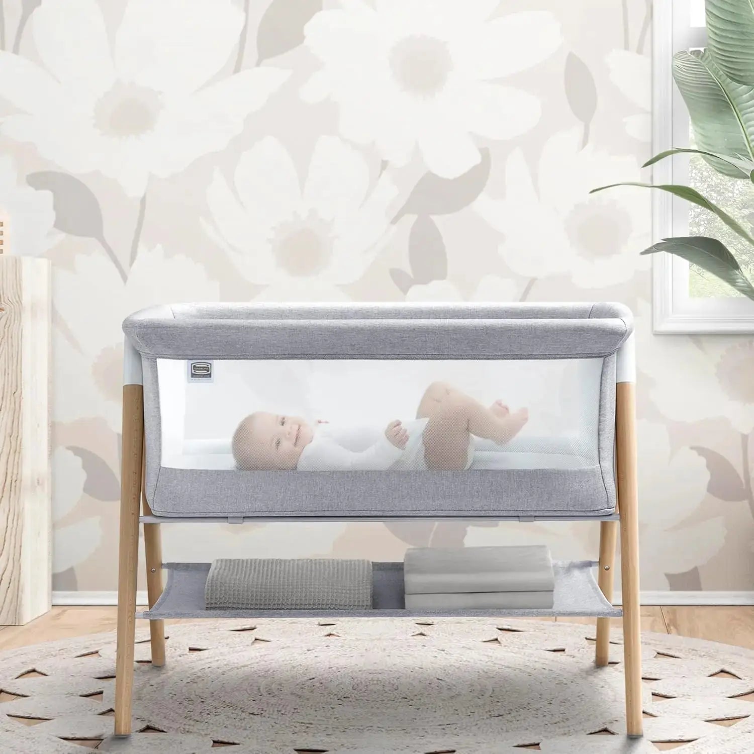 Koi by The Bed Bassinet with breathable mesh sides and natural beechwood legs in dove grey. Features a lower storage shelf, ideal for newborns and parents.