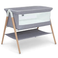 Koi by The Bed Bassinet with breathable mesh sides and natural beechwood legs in dove grey. Features a lower storage shelf, ideal for newborns and parents.