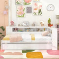 Twin daybed with trundle and storage in a cozy bedroom. Features a reversible bookcase headboard, wooden slats, and bedside shelves for organization.
