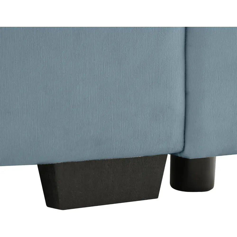 Velvet loveseat sofa with deep seating and storage ottoman in a modern living room. Plush upholstered design offers comfort and style.