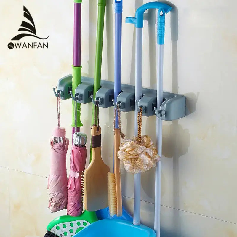 Close-up of a wall-mounted plastic bathroom shelf with a hook and rolling grip for holding mops and brooms. Multi-functional storage holder for washrooms and balconies.